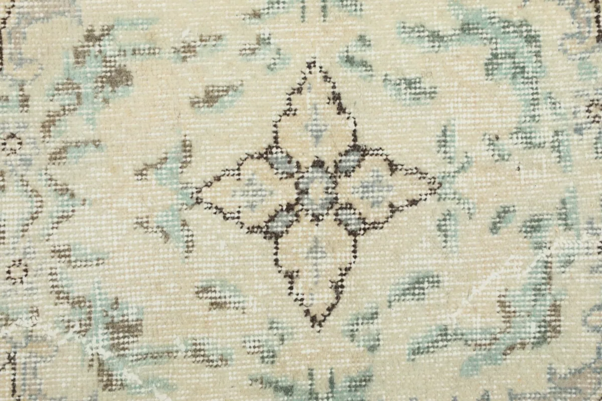 Macro detail showing the hand-knotted wool pile and faded blue and gray colors in the pattern