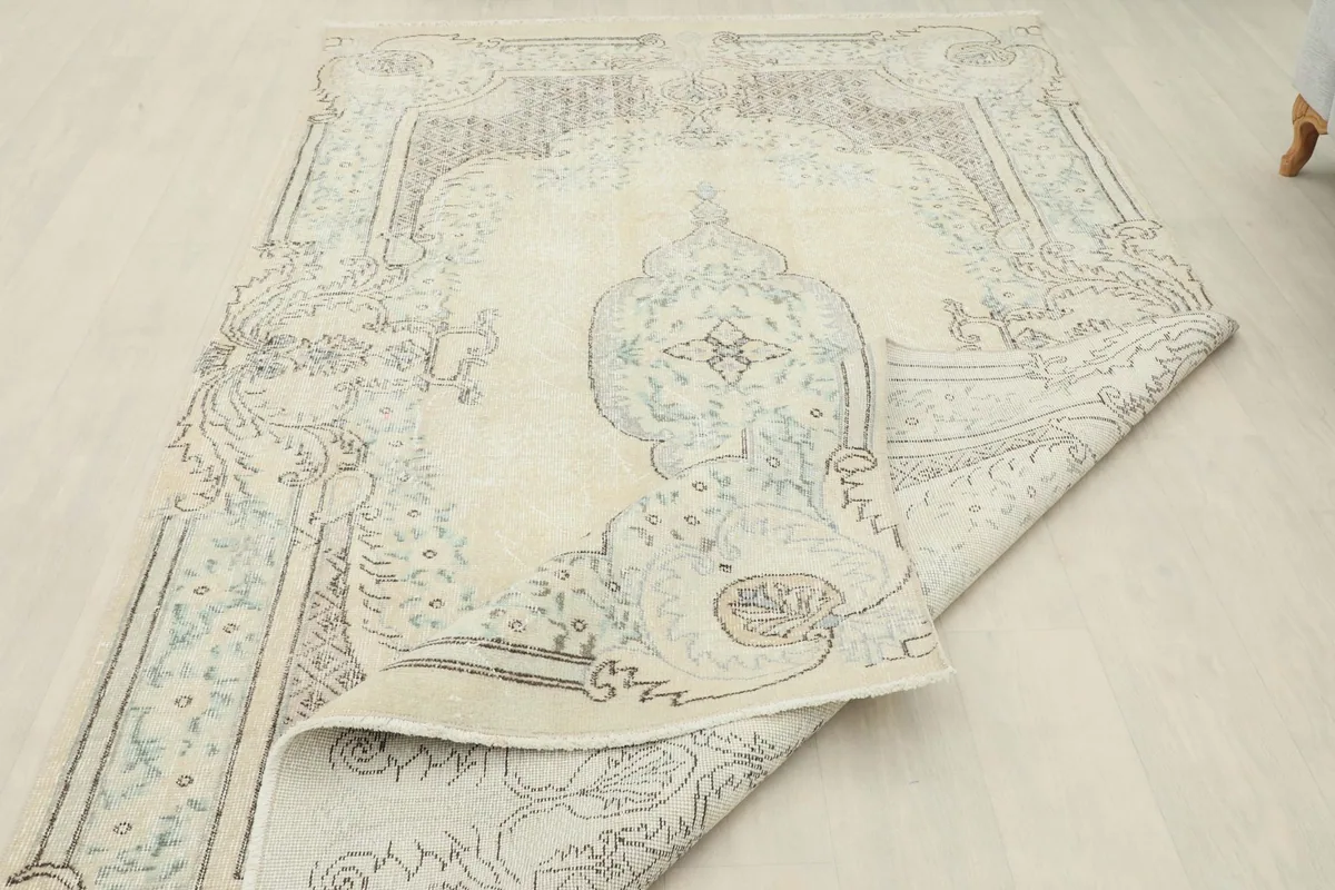 View of the rug folded back to reveal the back of the hand-knotted cotton foundation