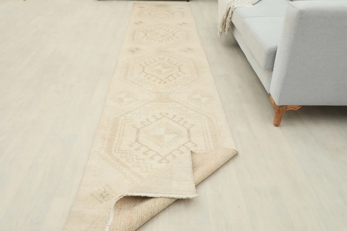 Runner rug partially unrolled in a room setting, showing its length and flexibility.