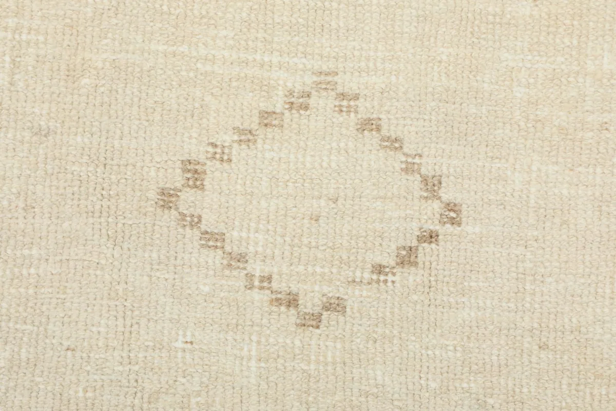 Detailed view of a small tan geometric diamond pattern on the rug