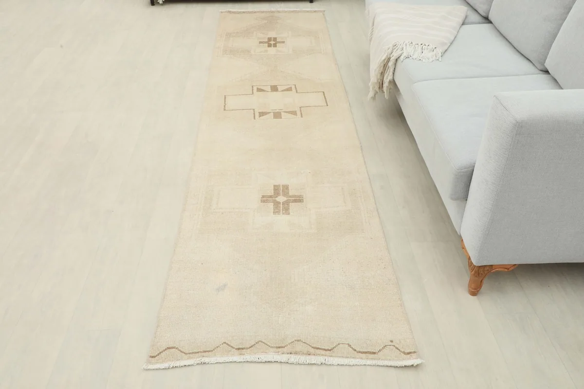 Full view of the ivory beige runner rug laid out in a room, showcasing its elongated shape and design.