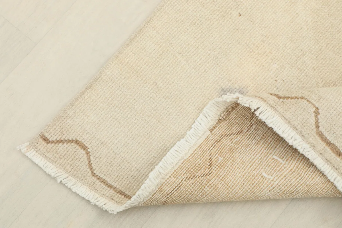 View showing the reverse side of the hand-knotted wool rug, revealing the cotton foundation.
