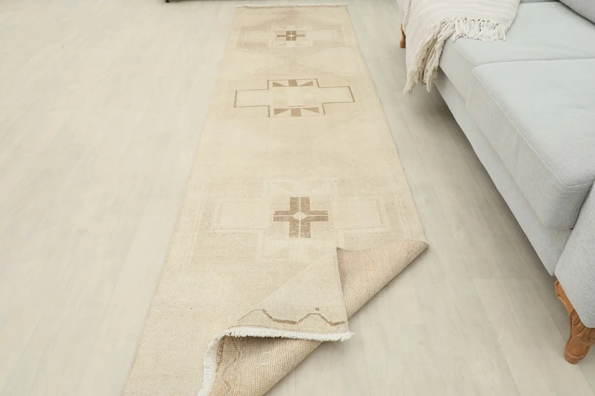 The runner rug partially folded to show its flexibility and the wool pile texture in a room setting.