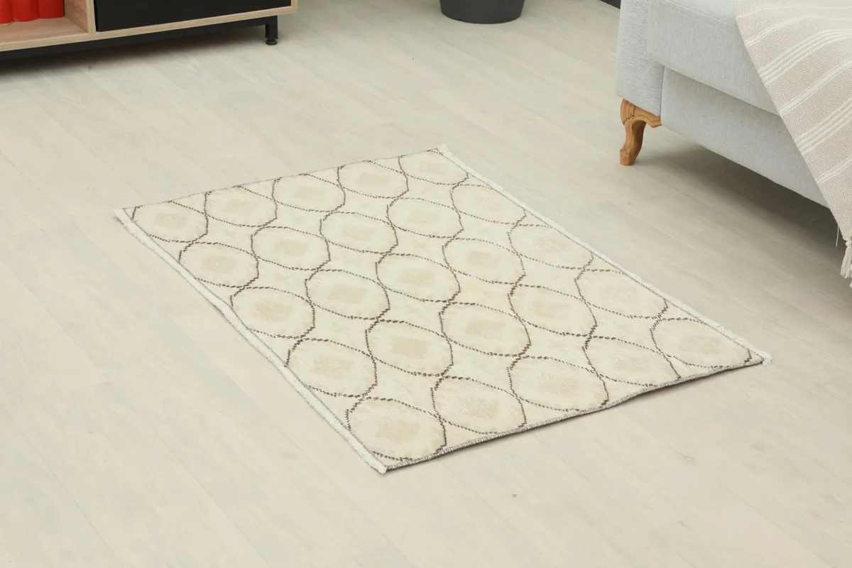Angled view of the cream and brown geometric rug on a light floor
