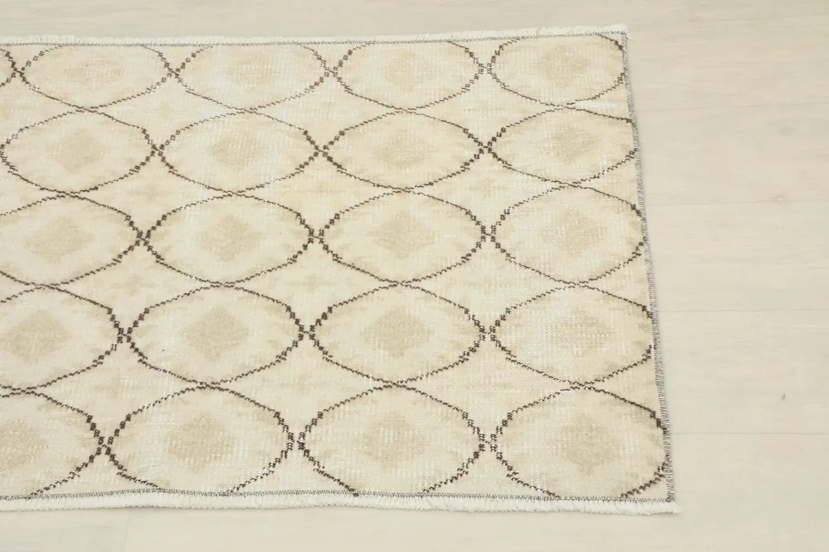 Close-up of the geometric pattern and cream field of the vintage rug
