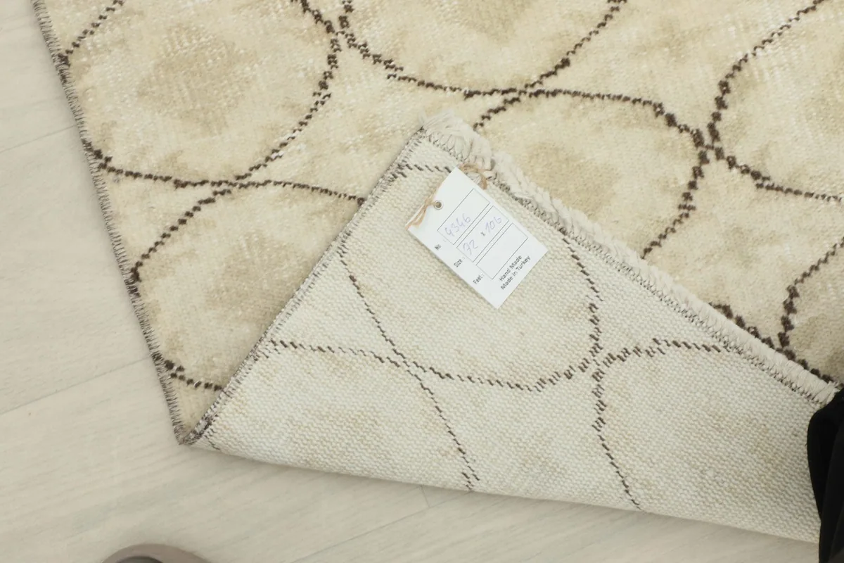 Close-up of the rug's label and craftsmanship on the reverse side