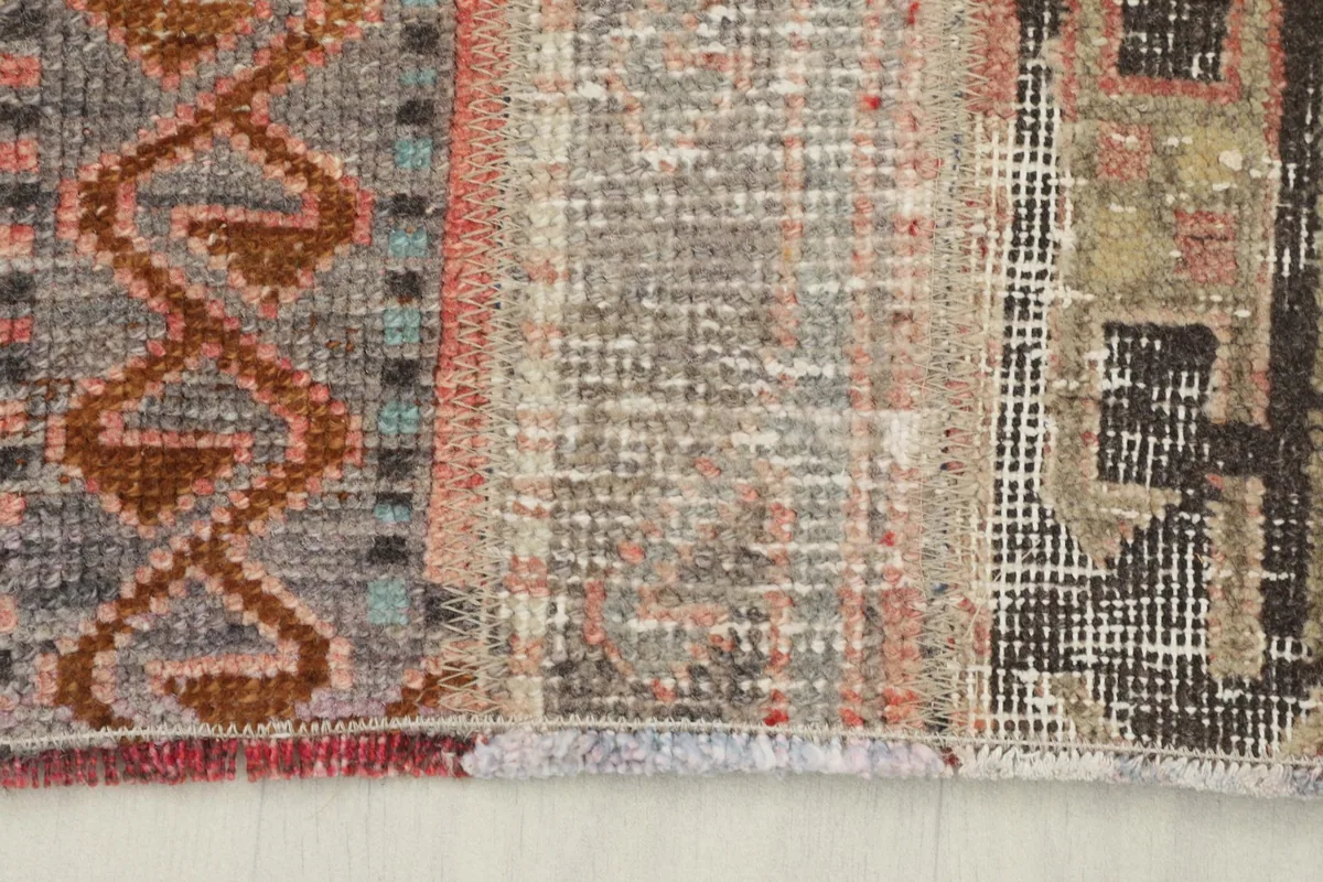 Extreme close-up of the low wool pile, showing wear and individual knots