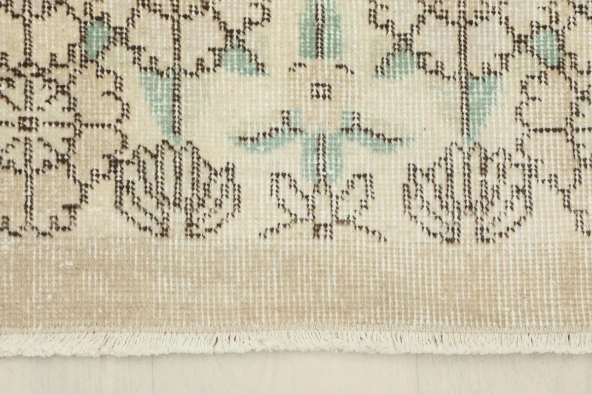 Close-up of the rug's end, showing the natural fringe and the woven edge with a border detail.
