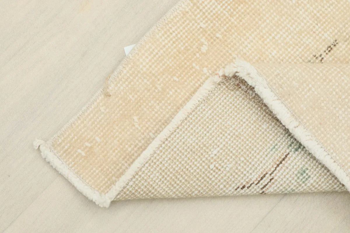 Close-up of the rug's cotton foundation from the reverse side, showing the hand-knotting.