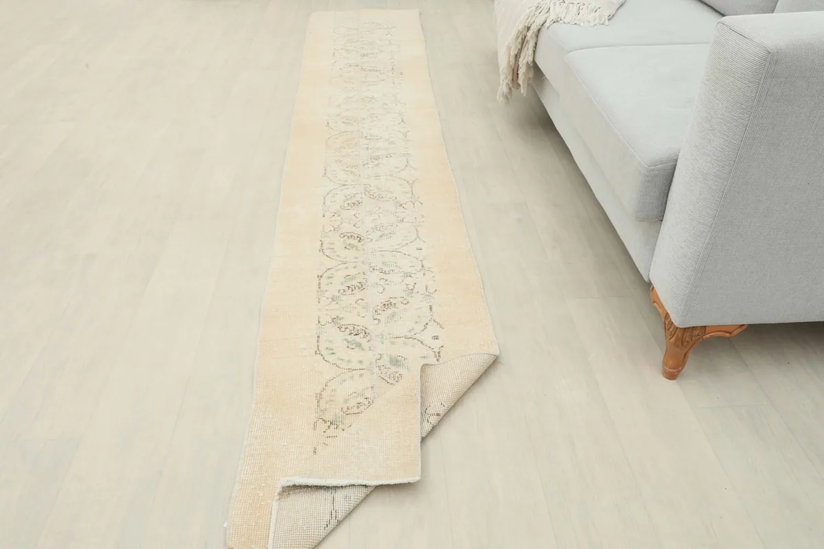 View of the runner rug partially folded, showing its flexibility and the reverse side.