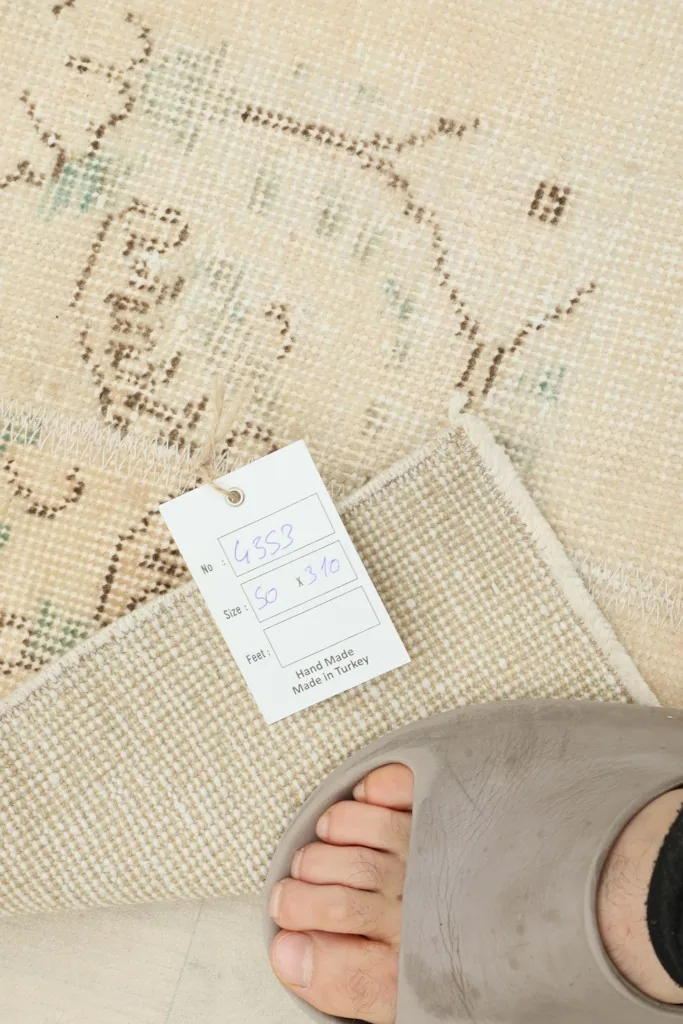 Close-up of the rug's back with a product tag showing dimensions and origin details.
