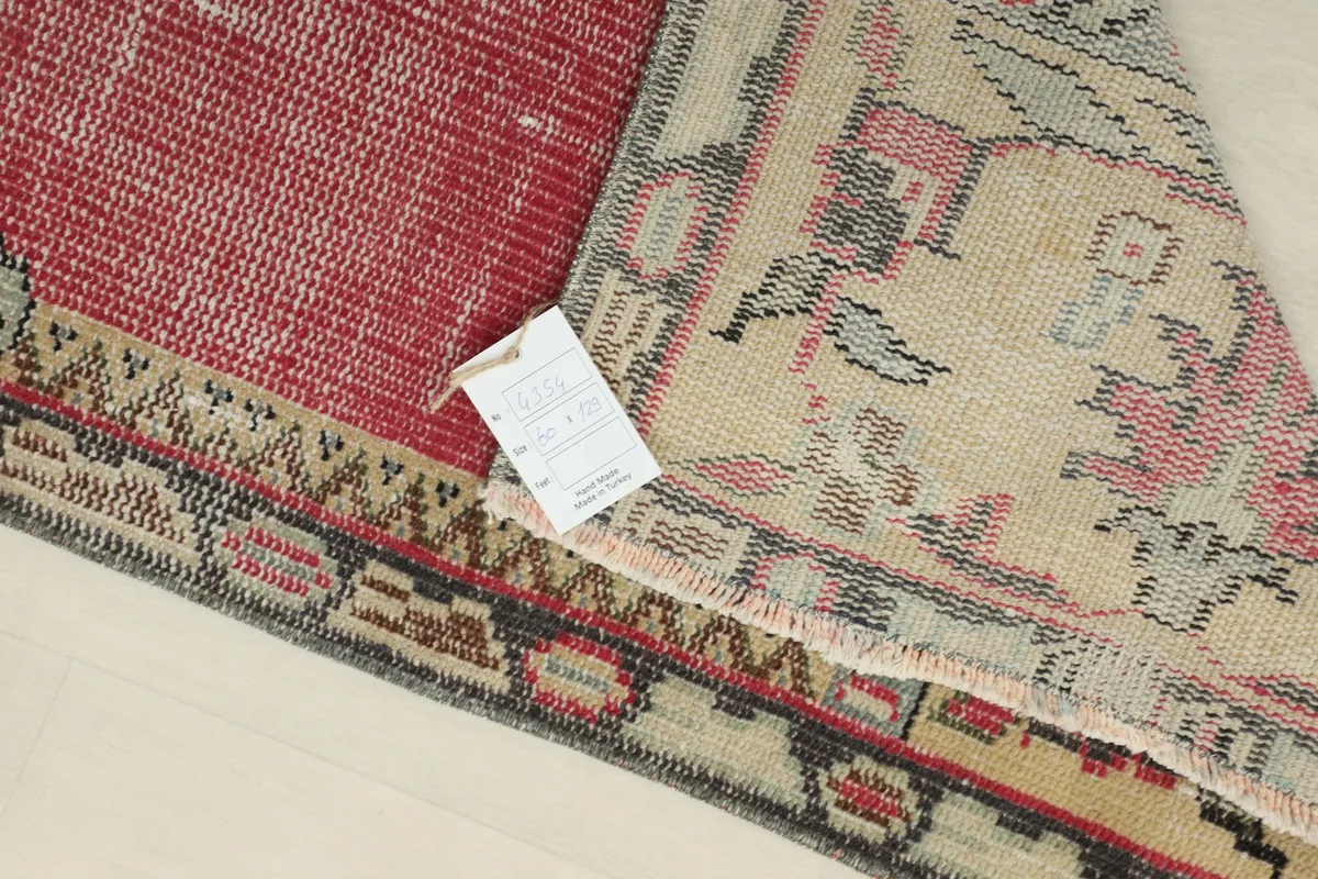 Close-up of the rug's back and pile, showing the natural wear and texture of the vintage wool