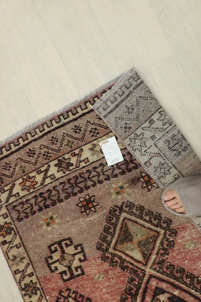 A foot partially on the rug, showing scale and texture of the low pile