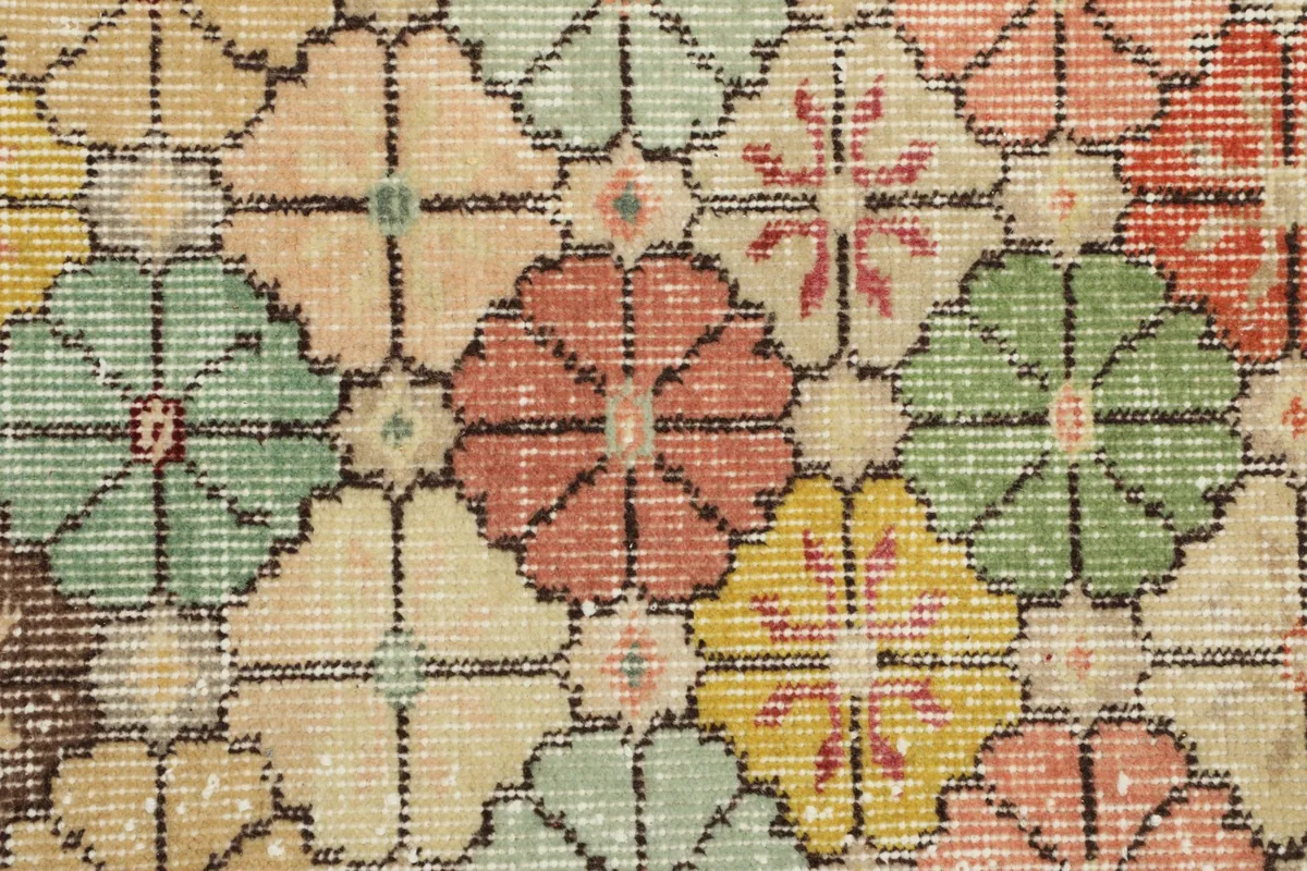 Close-up of the rug's texture and individual floral patterns, showing the wool pile and color variations.