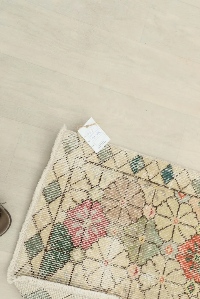 Overhead view of the rug's back and a small part of the top, showing the tag and construction.