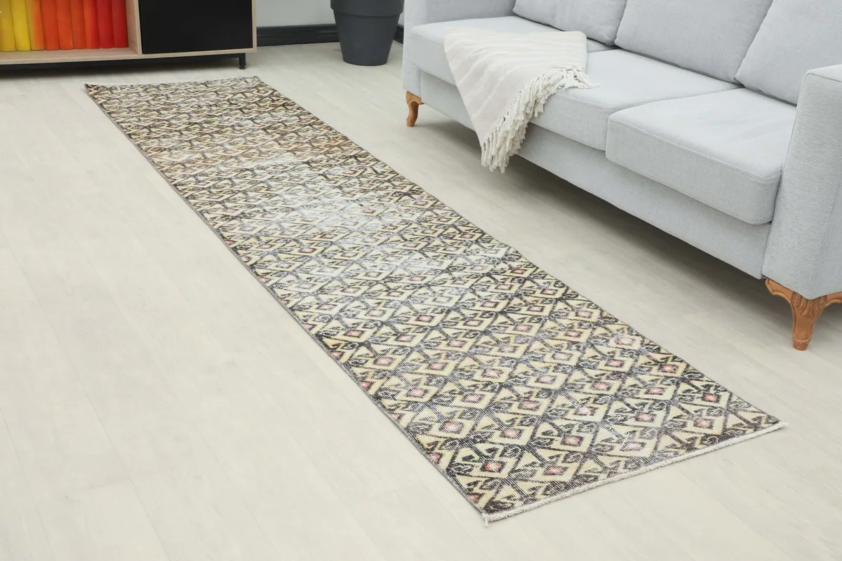 Angled view of the runner rug in a room, showing its length beside a sofa