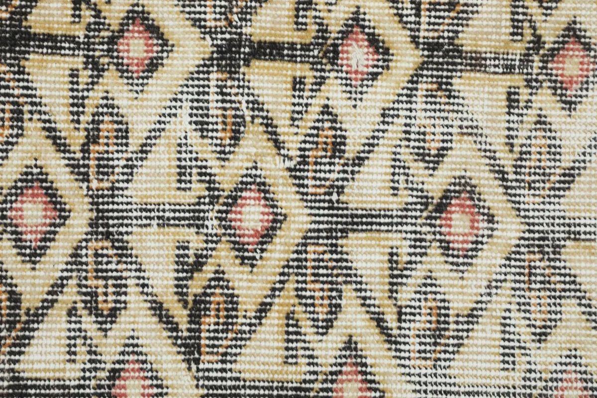 Tight detail shot of the hand-knotted wool pile and intricate geometric shapes
