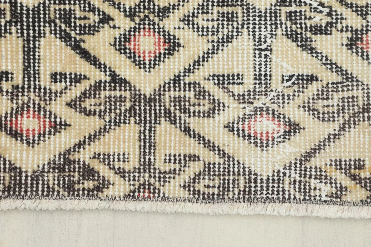 Close-up of the rug's edge, showing the short fringe and the tightly woven knots