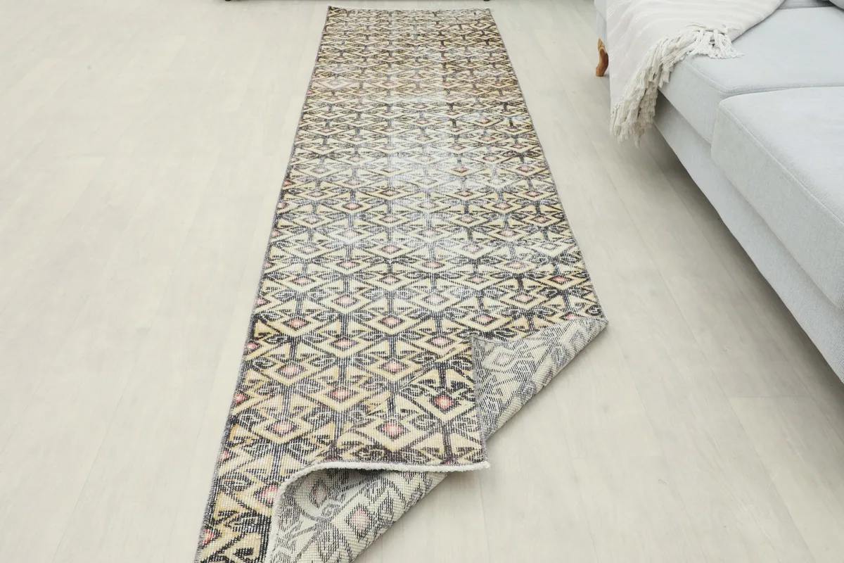 Runner rug partially unrolled in a room, demonstrating its flexibility and length