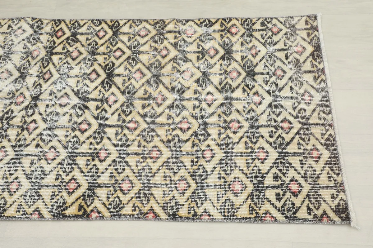 Close-up overhead view of the geometric pattern and color variations on the rug