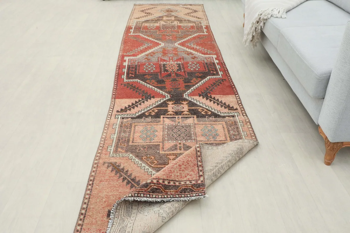 Runner rug partially folded back in a room setting, showing its length and texture