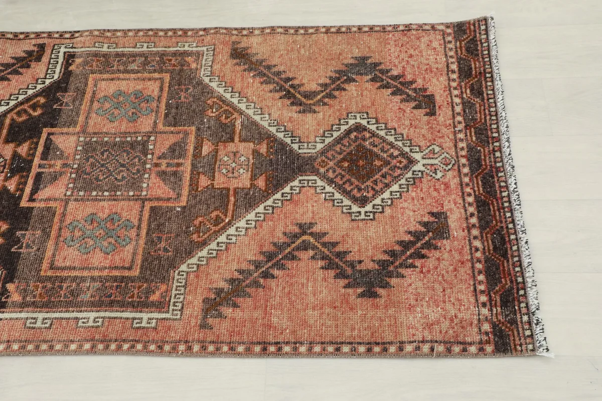 Close-up of one end of the runner showing rust, beige, and charcoal geometric patterns
