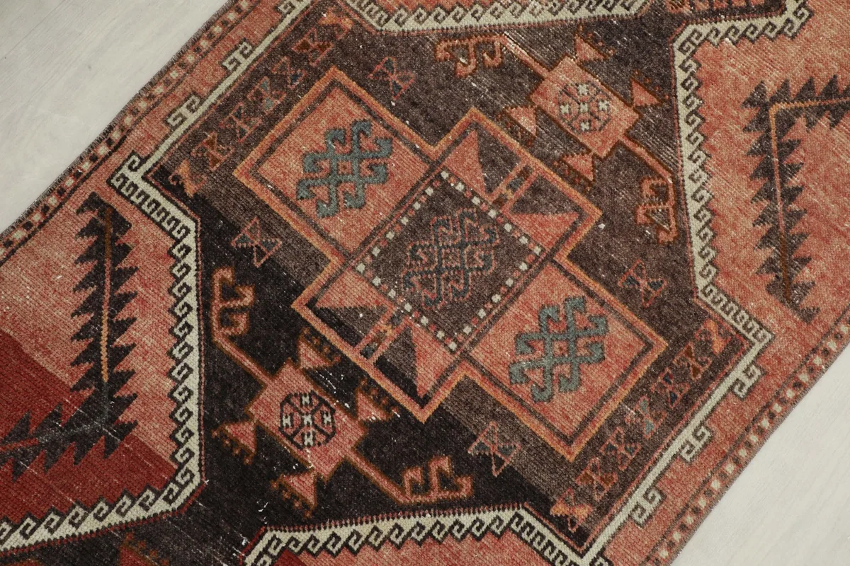 Angled close-up of the central geometric motifs and color variations in the rug pile