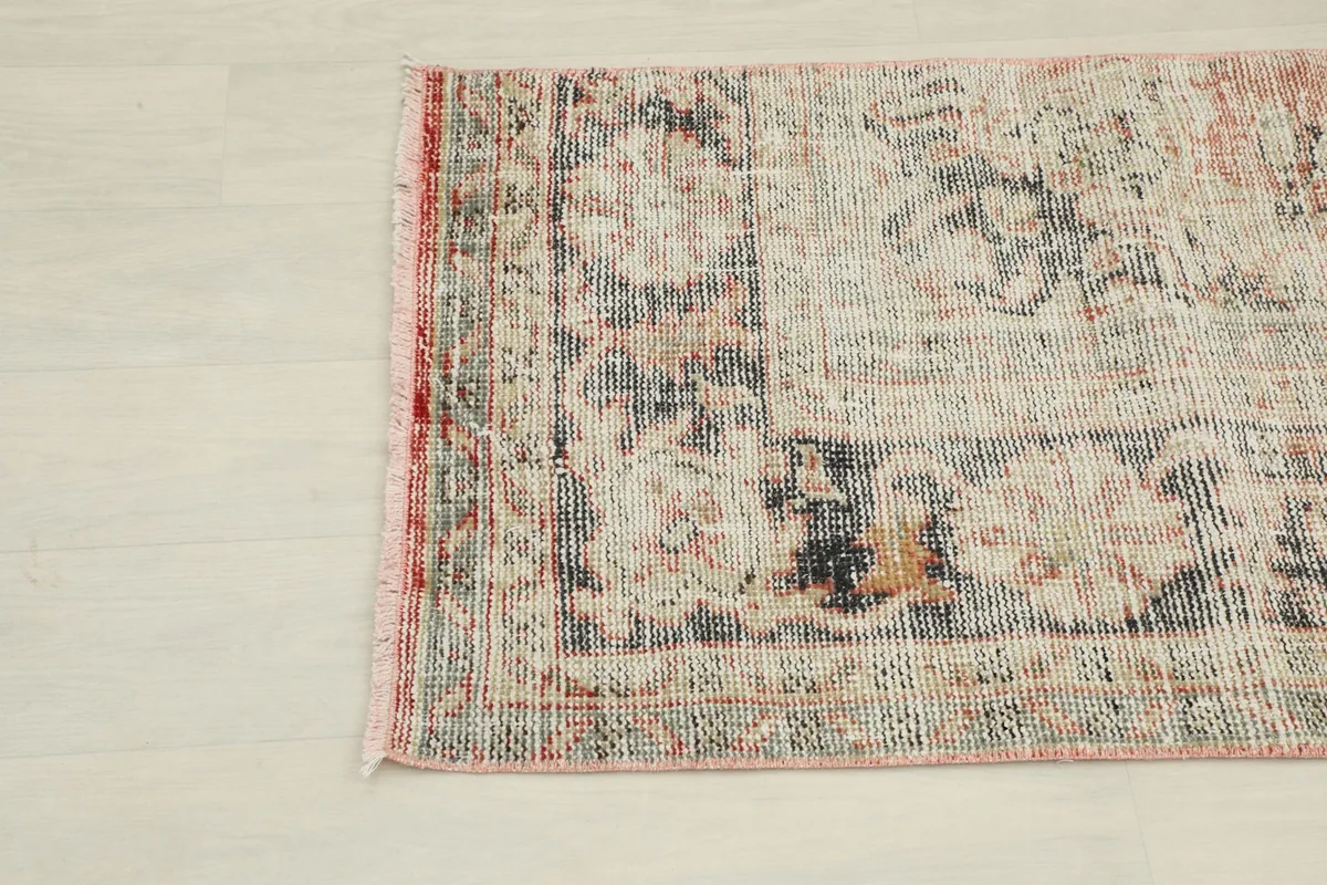 Close-up of the rug's lower section and fringe, detailing the worn texture and colors