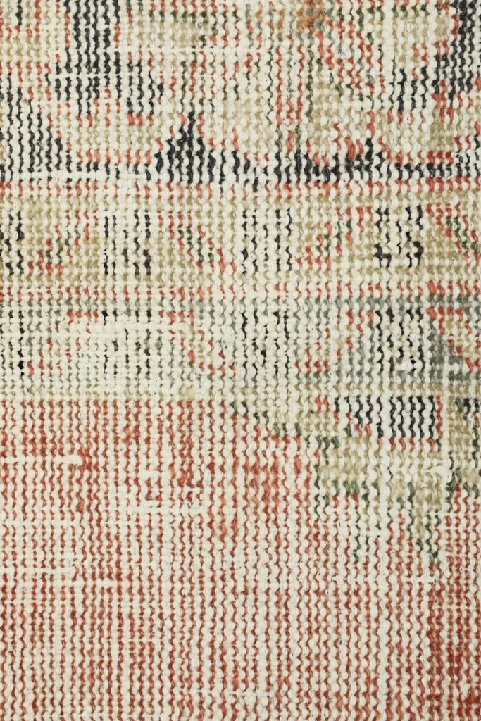 Extreme close-up of the low wool pile, revealing the hand-knotted construction and color blending