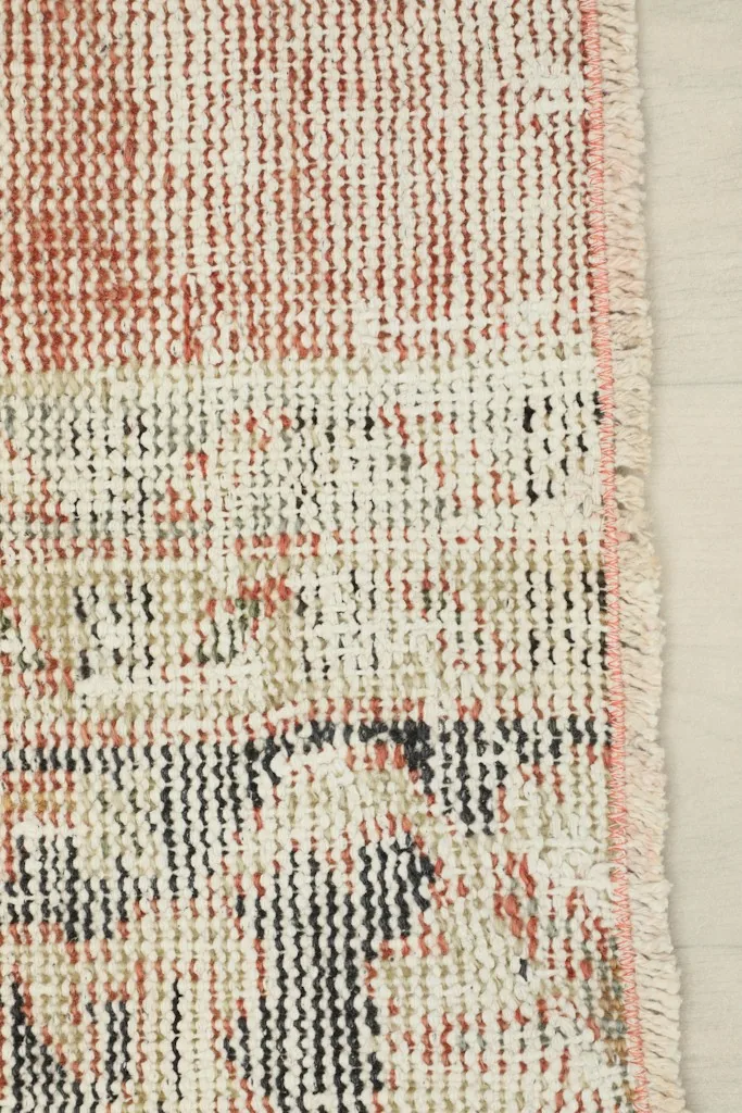 Close-up of the rug's short fringe and edge, showing the natural wear and finishing
