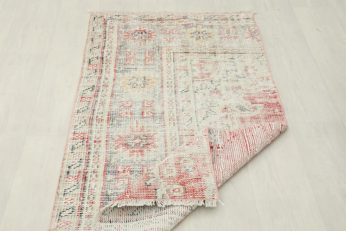 Rug folded to show the thickness and flexibility of the vintage hand-knotted wool material.