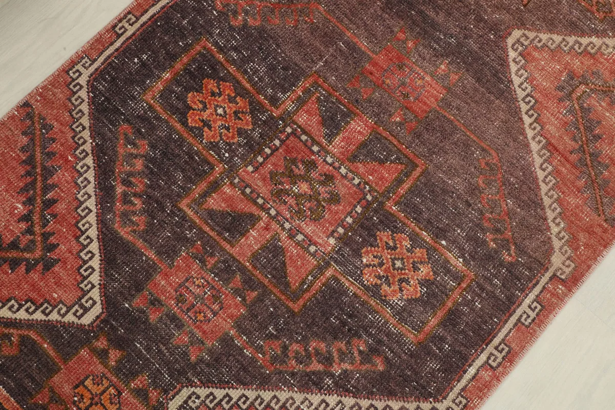 Detailed view of the central brown medallion and surrounding rust and beige geometric patterns.