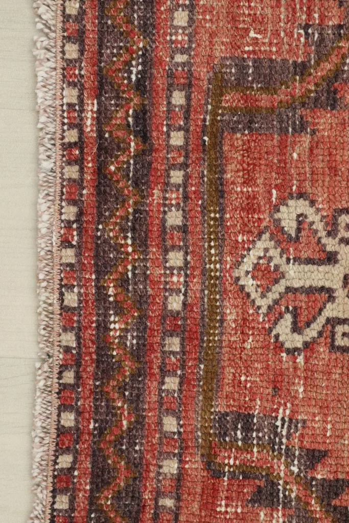 Close-up of the runner rug's edge, revealing the subtle fringe and border design details.