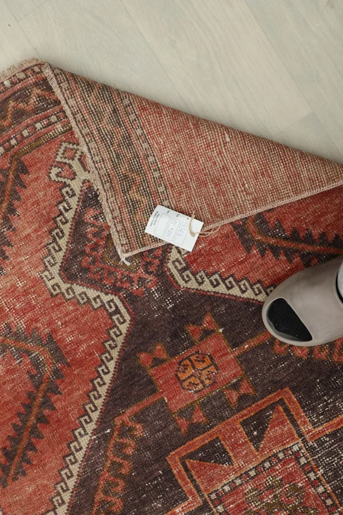 Overhead view with a foot for scale, highlighting the rug's texture and colors.