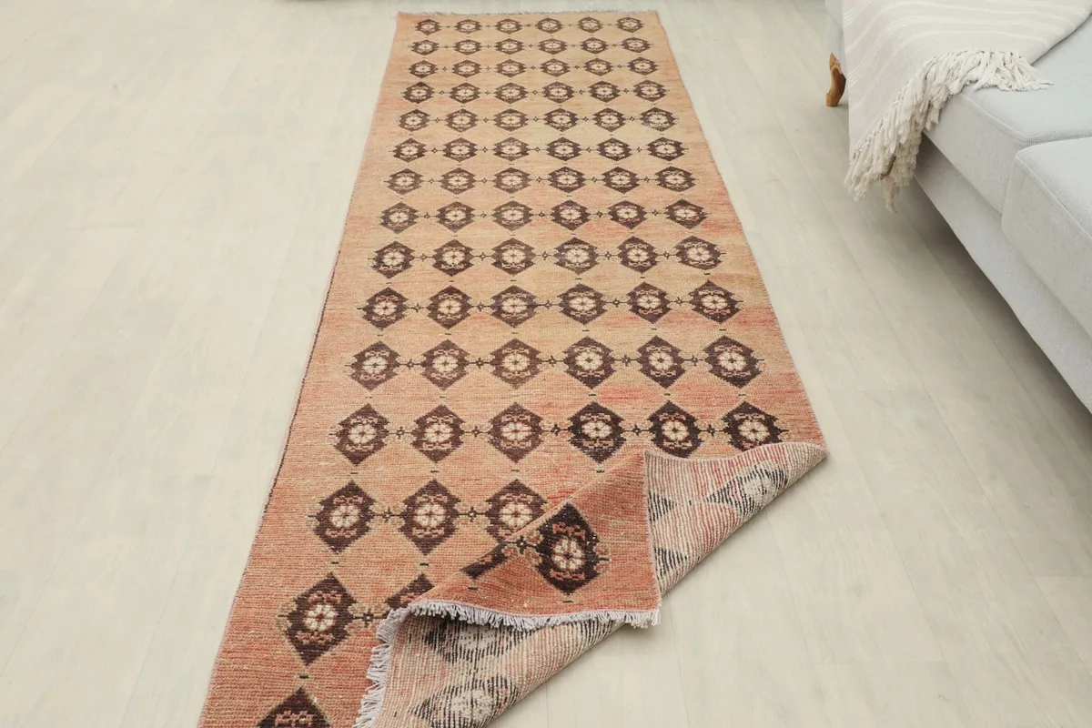View of the runner rug partially unrolled in a room setting, showing its length and pattern