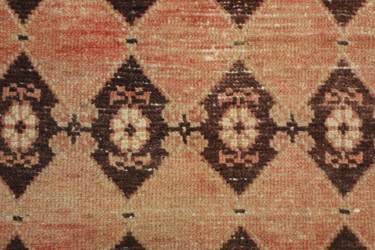 Detailed view of the low wool pile and the intricate hand-knotted geometric pattern