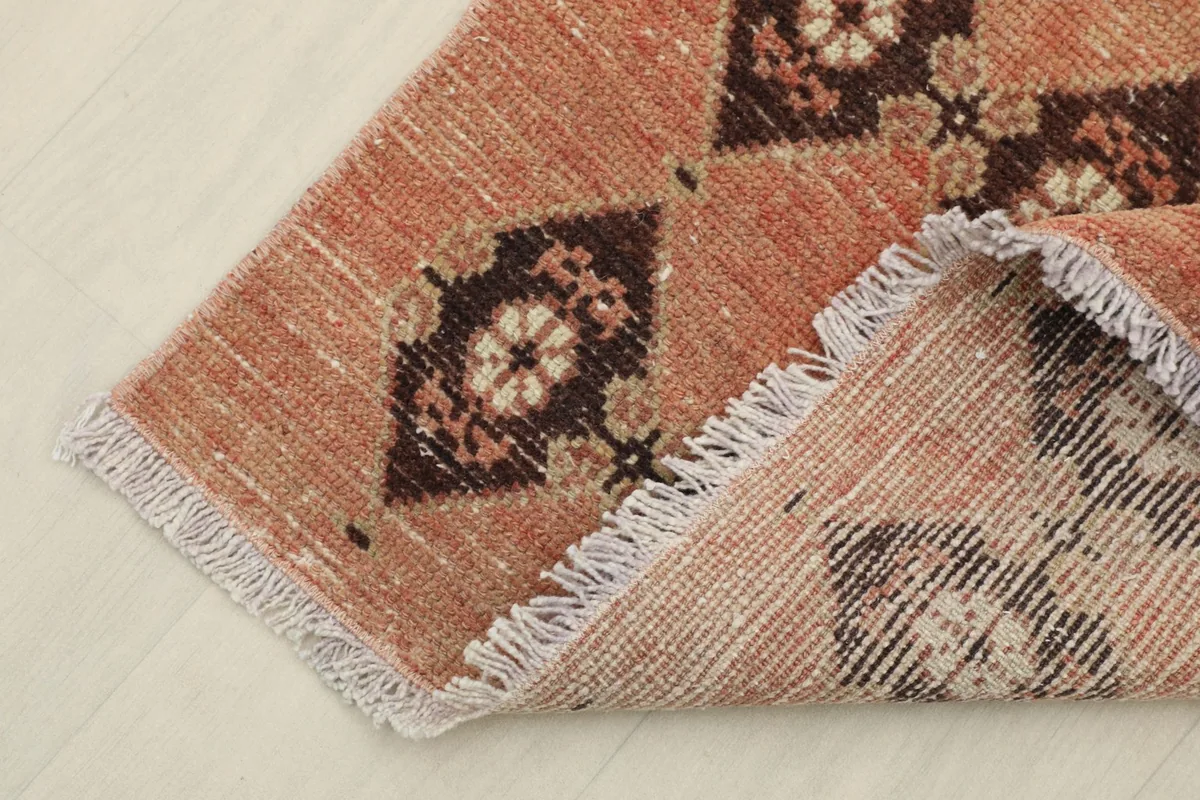 Corner of the rug folded back, revealing the wool pile on cotton foundation