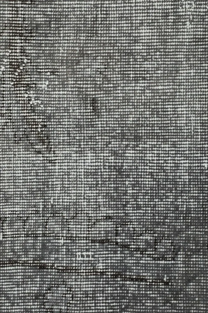 Overhead close-up showing the low pile and intricate weave of the vintage wool rug