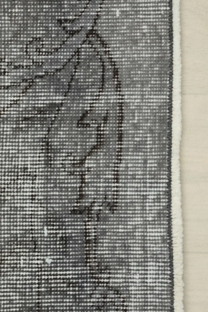 Close-up of the rug's edge, displaying subtle fringe and the side binding