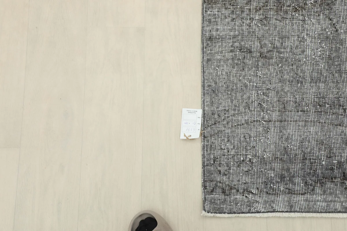 Overhead shot of the rug's end with a size tag, providing context for its dimensions