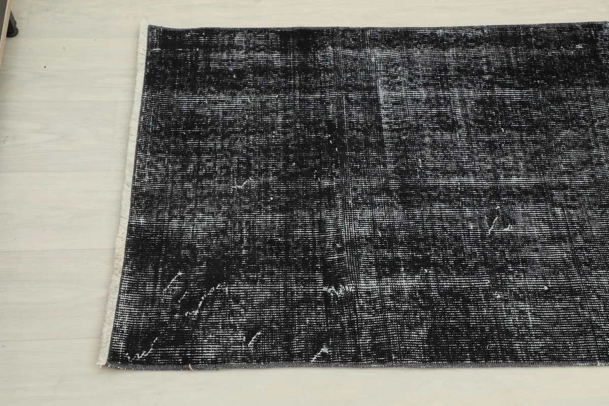 Angled view of the other end of the vintage runner, detailing the subtle color variations and hand-knotted fringe.