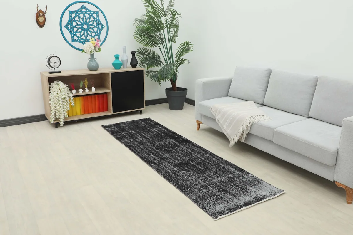 Vintage runner rug in a modern living space, showing its charcoal and gray tones complementing light decor.