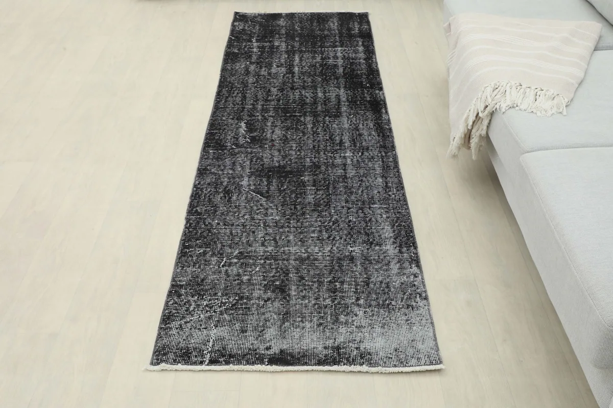 Full overhead view of the charcoal and gray runner rug in a room setting, showcasing its complete design.