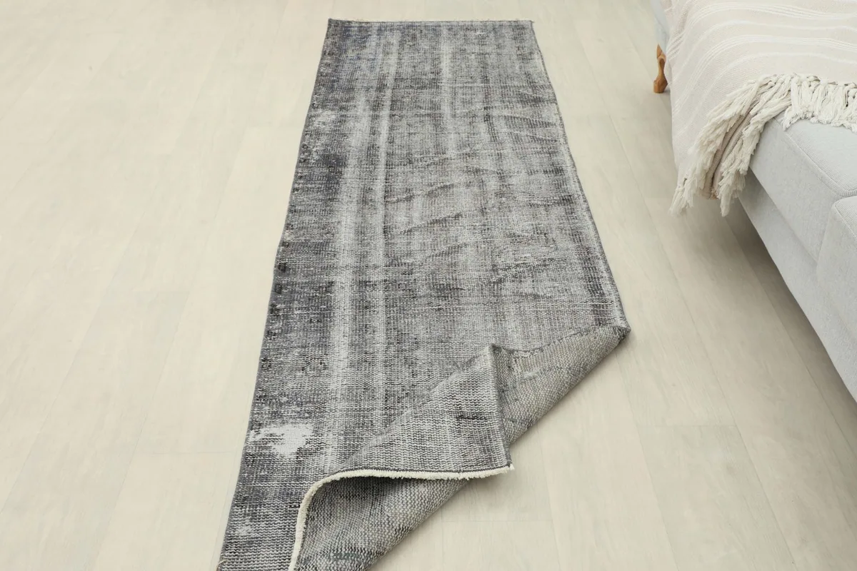 Runner rug with one end folded, displaying the low pile and the clean back of the vintage piece.