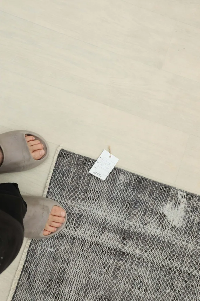 Feet standing next to the rug, providing a sense of scale for the 2'4" x 7'8" runner.