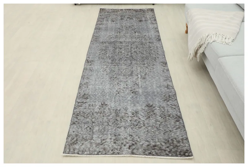 Full overhead view of the charcoal gray vintage runner rug on a light floor