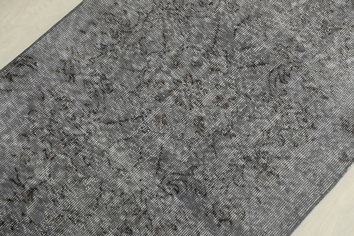 Close-up detail of the charcoal gray wool pile and subtle faded patterns