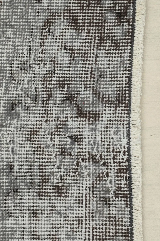 Detail of the rug's edge and fringe, showing the cotton foundation