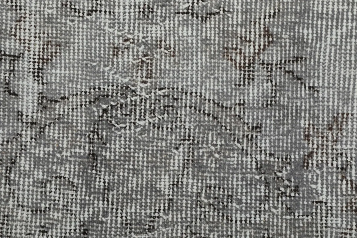 Extreme close-up of the low wool pile and hand-knotted texture of the rug