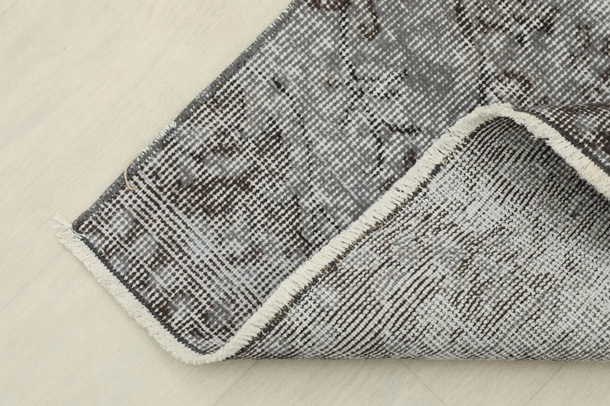 Close-up of the back of the hand-knotted rug, showing the cotton foundation
